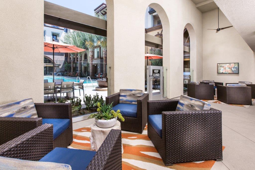 Clubhouse with wicker furniture and large windows overlooking the pool.